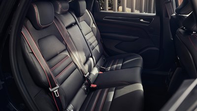 one man and one woman sitting in the backseats of the renault arkana